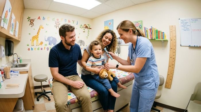 Young parents with a toddler at a pediatric preventive care appointment
